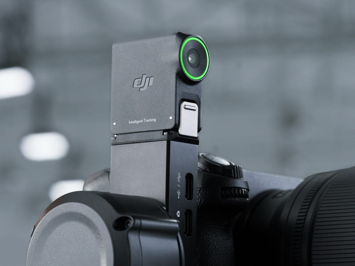 Ảnh chụp cận cảnh gimbal DJI gắn trên thân máy ảnh với đèn báo xanh nổi bật