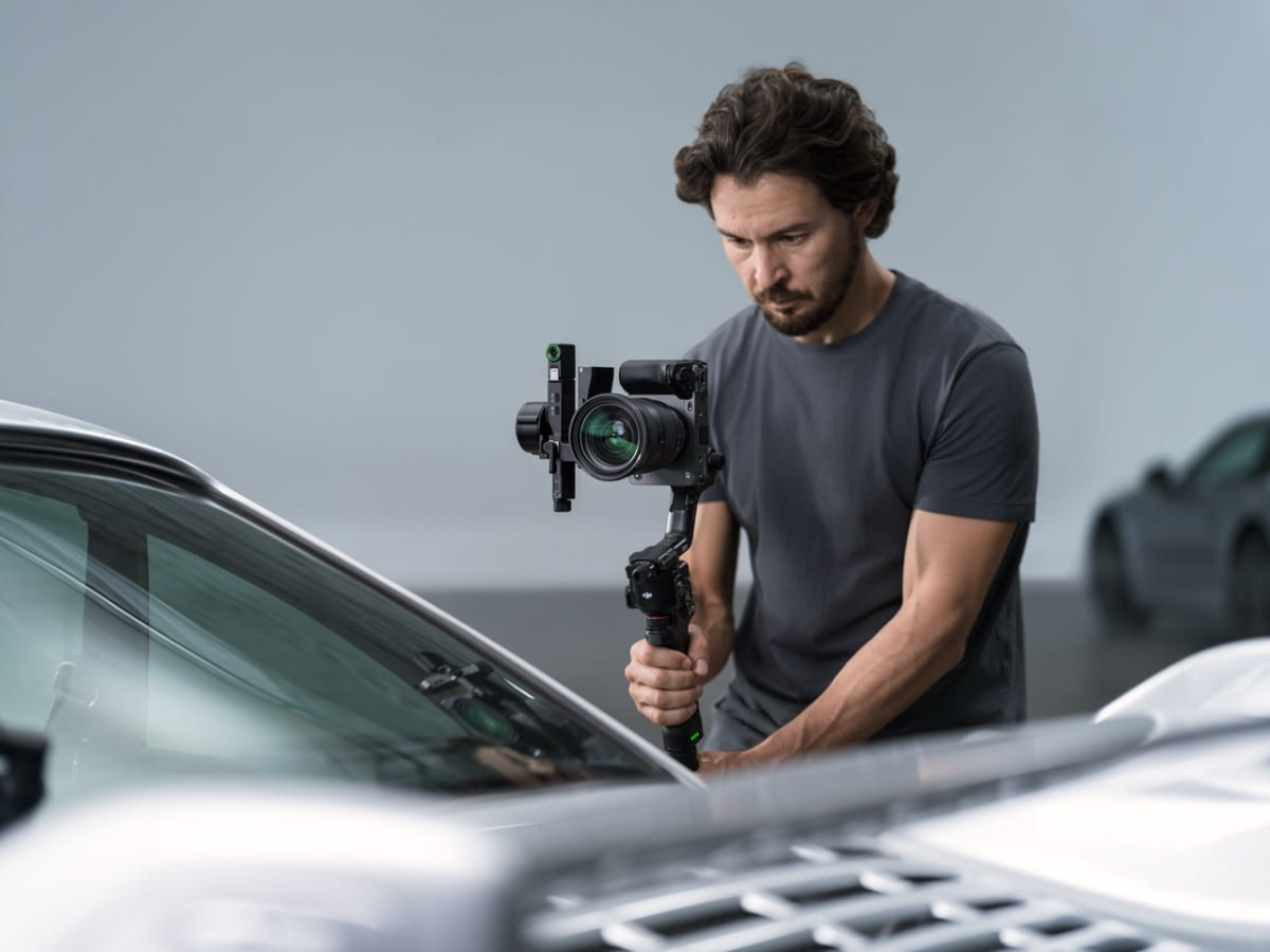 Thợ quay phim đang căn chỉnh gimbal RS 5 trước chiếc xe hơi trong studio