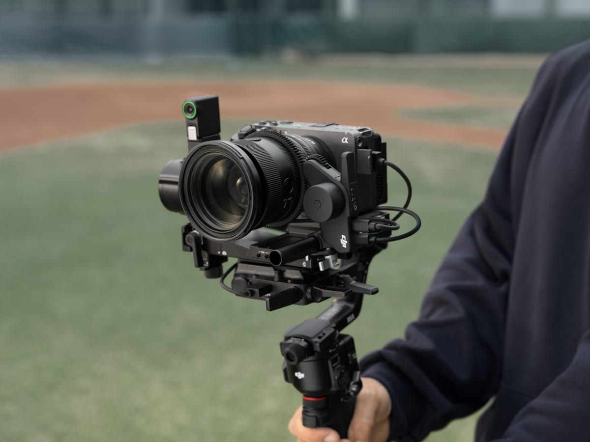Cầm gimbal RS 5 và máy ảnh Canon tại sân thể thao ngoài trời