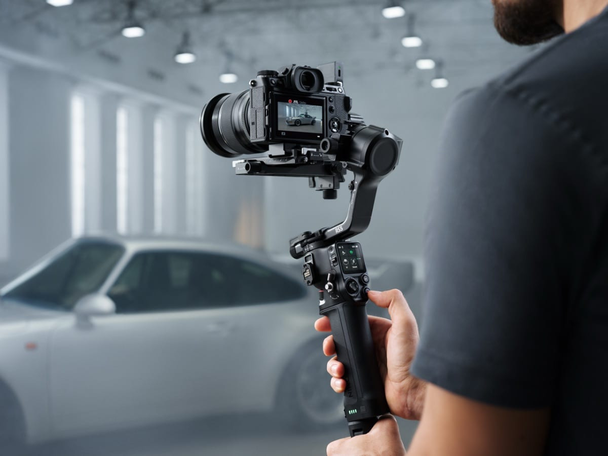 Chuyên gia đang cầm gimbal RS 5 gắn máy ảnh quay trong bối cảnh bãi đỗ xe