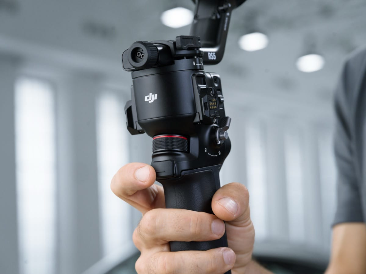 Cầm chắc gimbal DJI RS 5 màu đen trong bối cảnh nội thất hiện đại