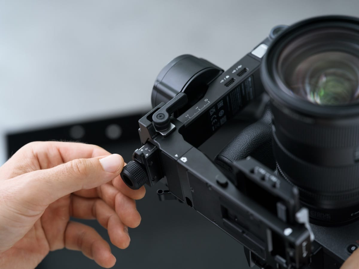 Ảnh chụp cận cảnh bàn tay thao tác với gimbal RS 5 gắn trên thân máy ảnh