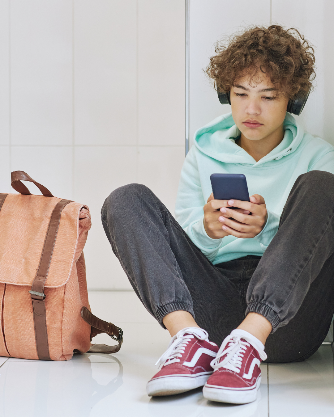 Adolescent assis avec des écouteurs, en train d'écouter un audio