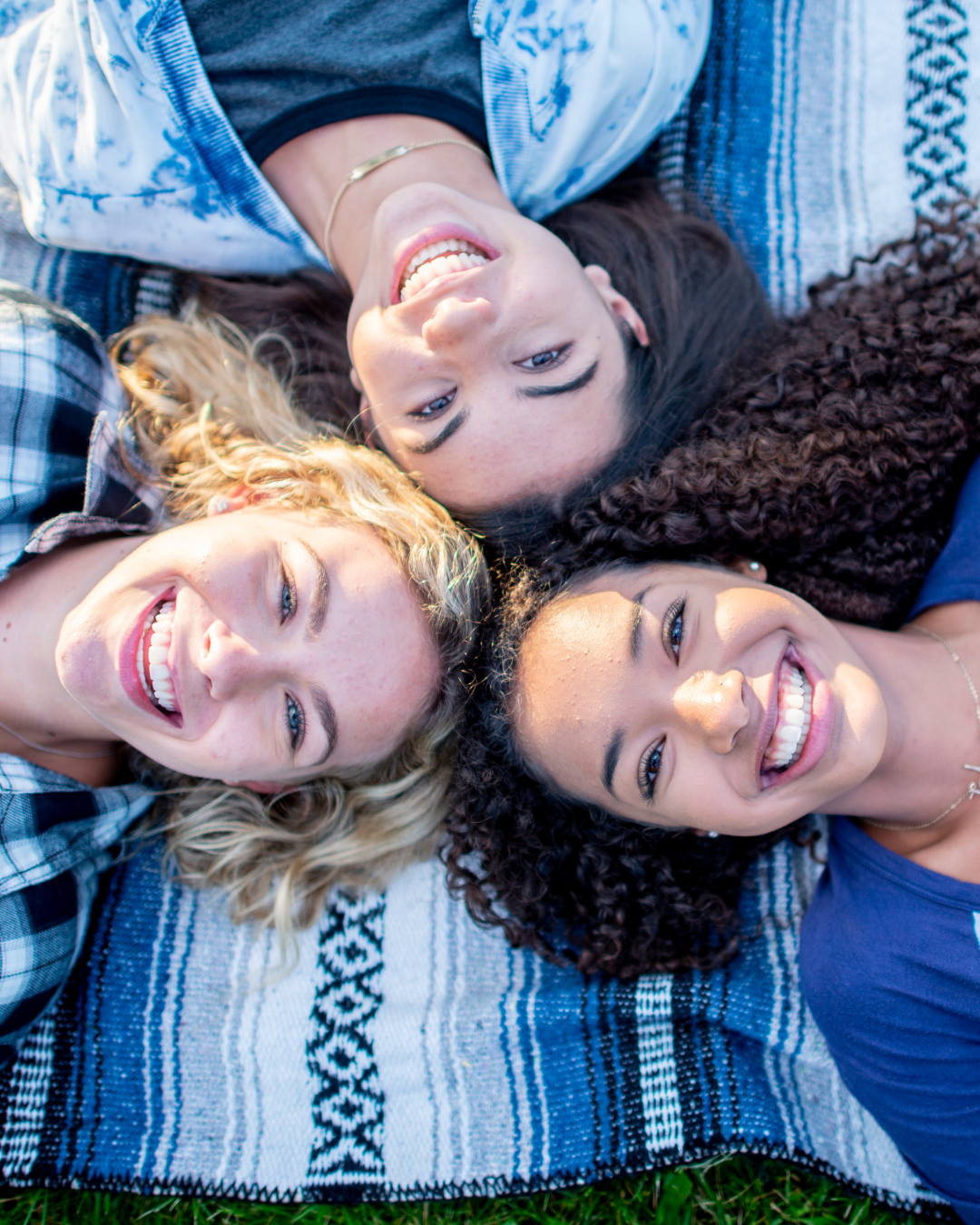 Trois adolescentes souriantes allongées ensemble