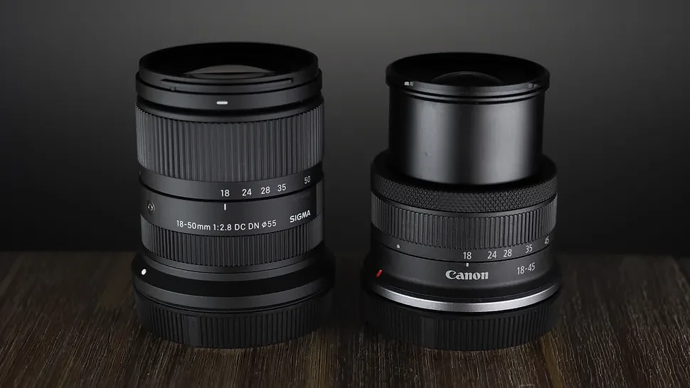 The Sigma 18-50mm f/2.8 DC DN | C Canon RF lens on a wooden surface against a dark background with moody lighting
