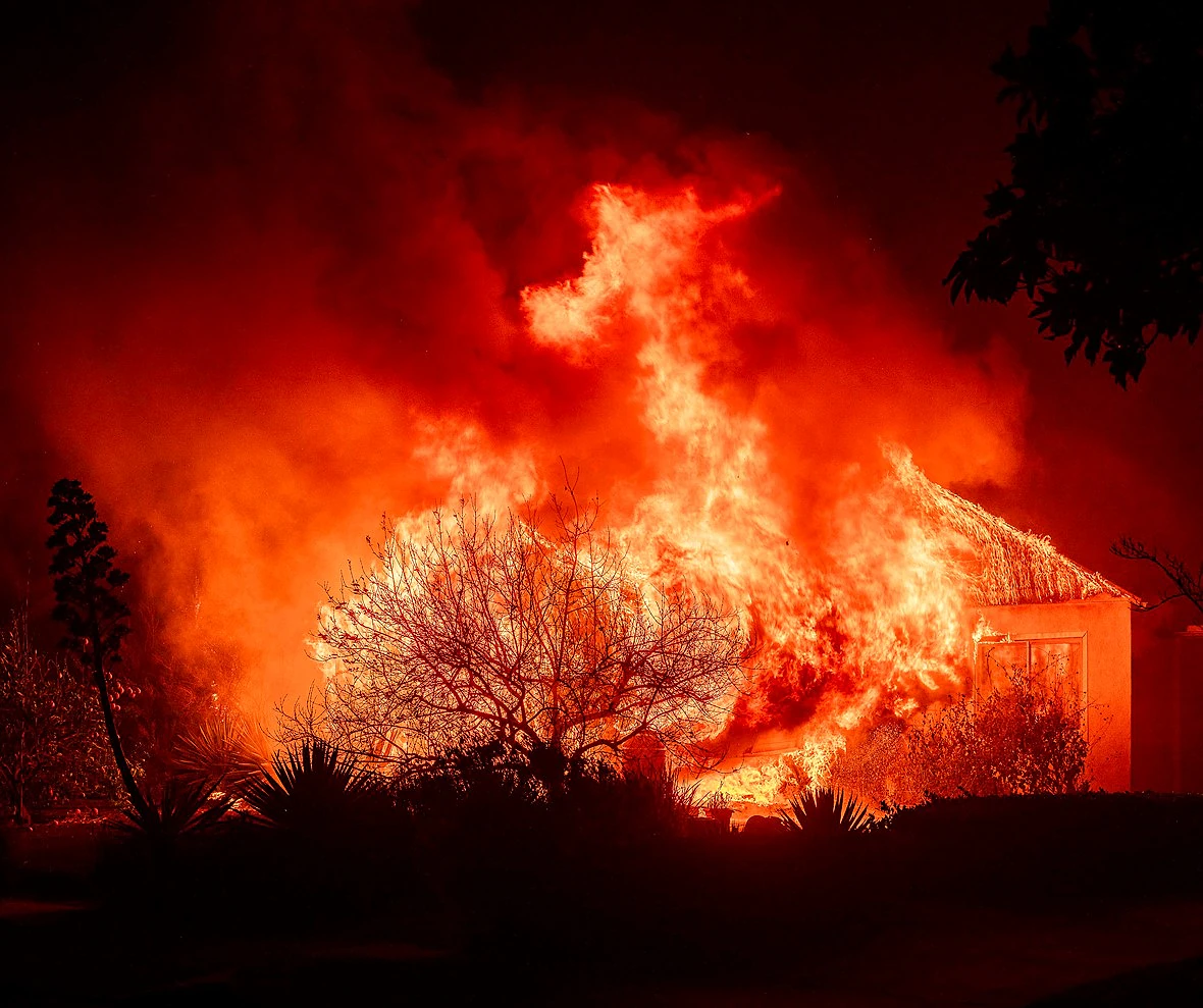 flames engulf a structure with smoke filling the night sky