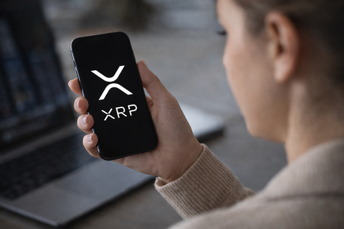 investor viewing xrp cryptocurrency logo on smartphone screen.png