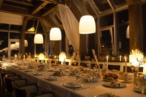 A beautifully arranged long dining table with candles and soft lighting, perfect for a special event.jpg