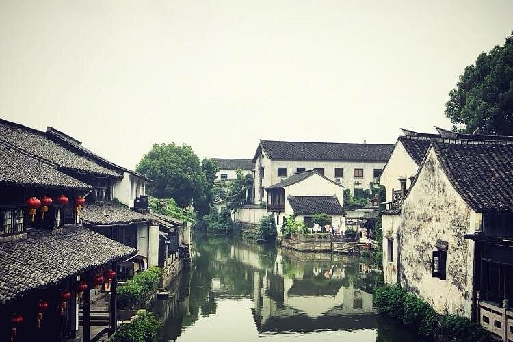 Shaoxing canal with whitewashed traditional buildings on both sides reflecting in calm water