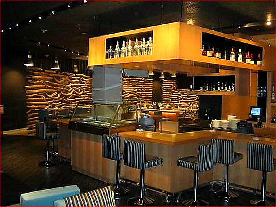 Bright colorful hero photo of a stainless commercial kitchen exhaust hood over a cooking line