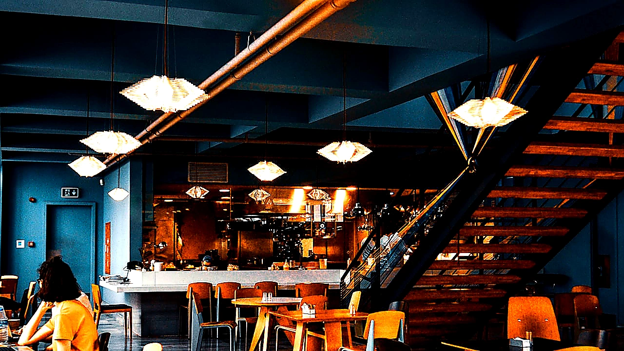 Bright colorful hero photo of a stainless commercial kitchen exhaust hood over a cooking line