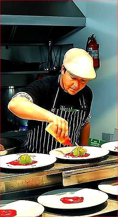 Vivid mid-article photo of chefs working under a well-lit CaptiveAire-style canopy hood