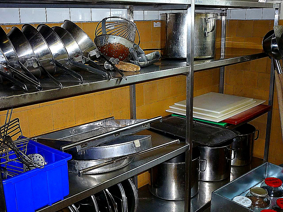 Vivid mid-article photo of chefs working under a well-lit CaptiveAire-style canopy hood