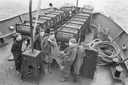 royal navy crewman next to the stern depth charge racks on v0 0r84kuuvb17c1.webp