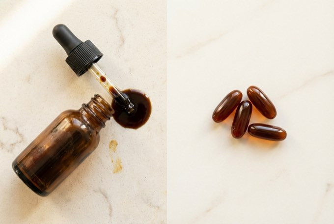 Messy black seed oil dropper bottle next to clean, odorless Sabel softgels