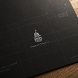 Spinus Studio Dark Logo Card on Wood