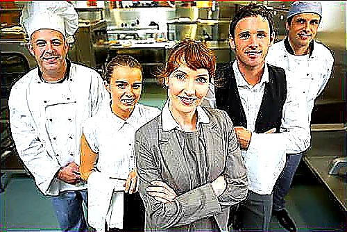 Bright colorful hero photo of a modern restaurant kitchen with glowing hood lights and chefs plating vibrant dishes