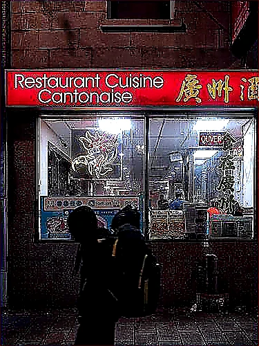 Vivid mid-article photo of restaurant operators studying colorful trade-area maps and analytics screens beside a busy open kitchen