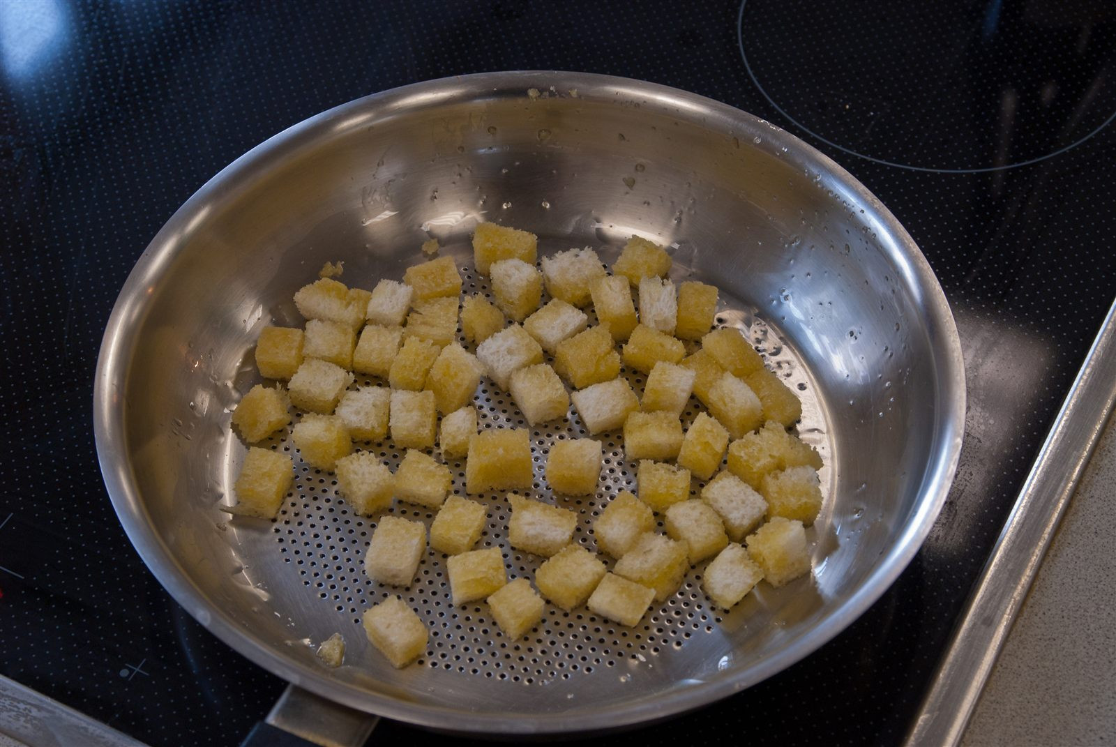 Golden croutons crisping in a pan