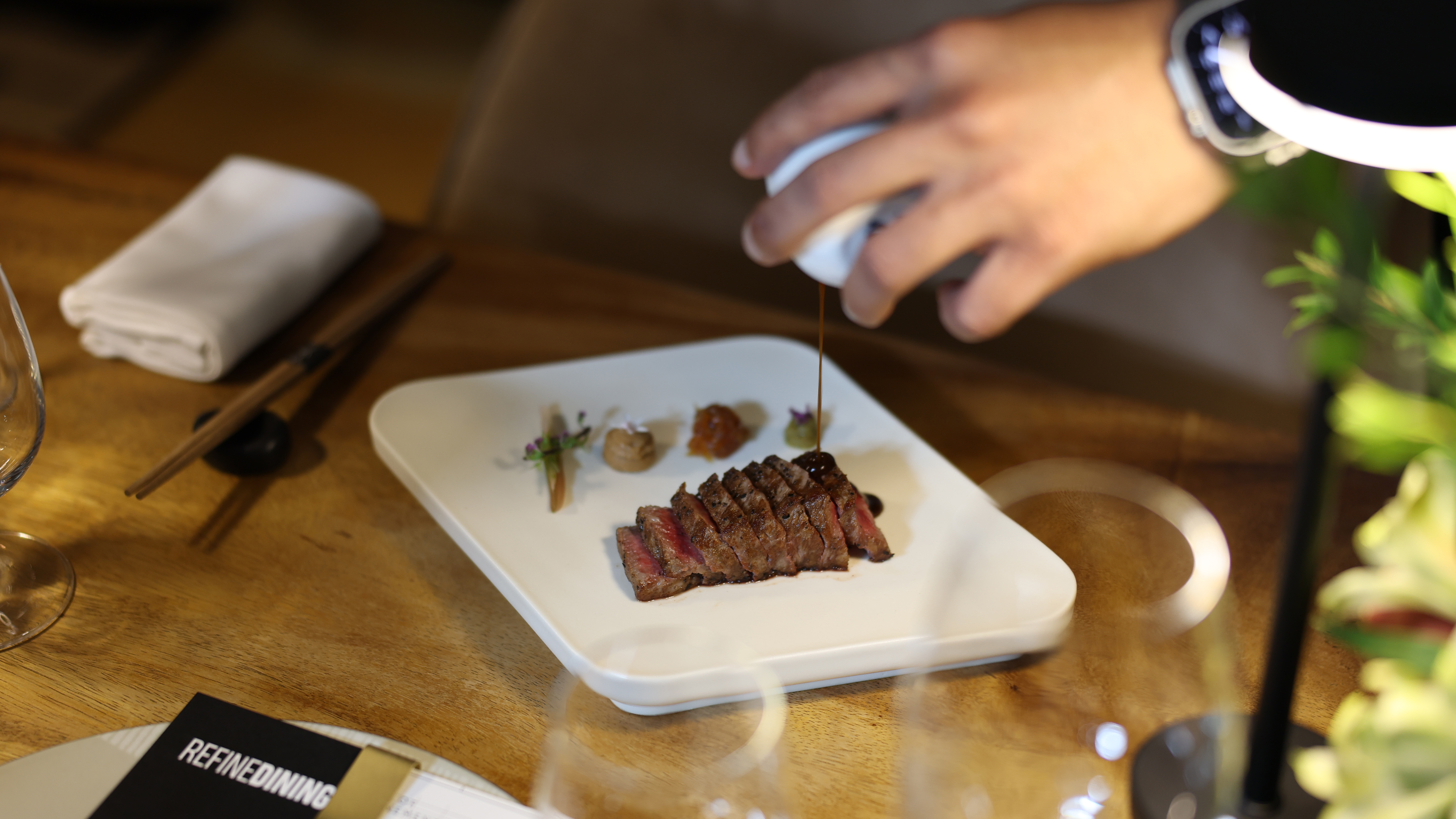 A course finished tableside with sauce poured over the dish