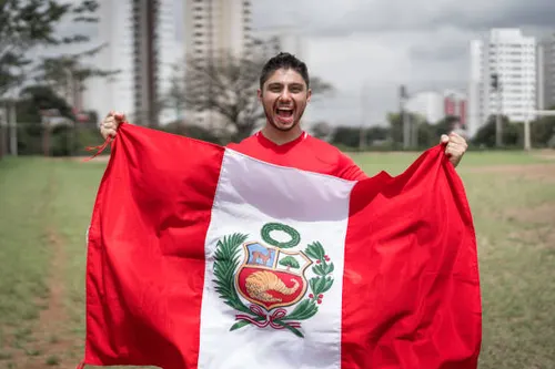 retrato fan masculino sosteniendo bandera peruana.webp