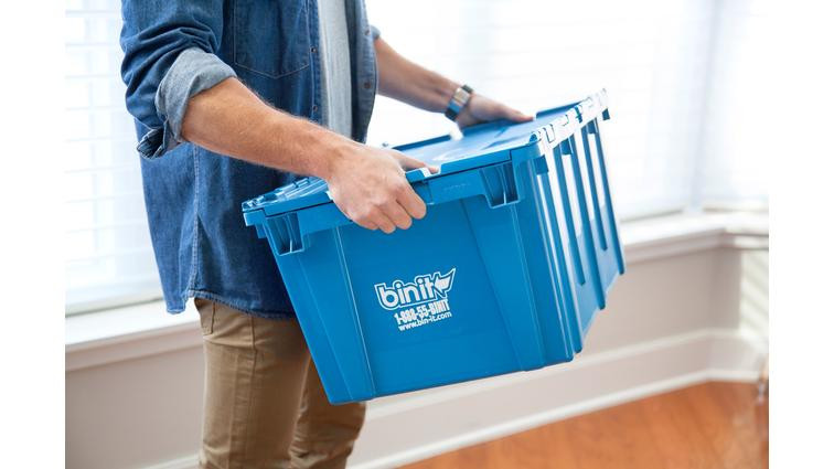 Person holding a plastic moving bin.