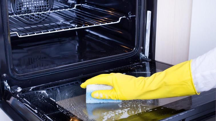 None Hand with a sponge wiping out an oven