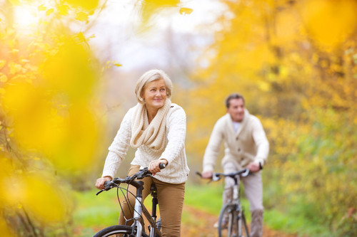 Active seniors riding bikes in autumn nature. They having romantic time outdoor..jpg