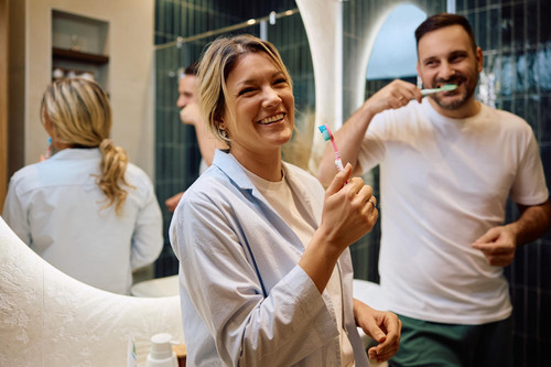 cheerful woman brushing teeth with her husband bathroom 1326977 12860.jpg