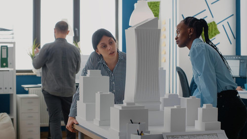 team architects working with building model maquette plan construction layout colleagues doing teamw.jpg