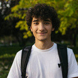 He is smiling and looking at camera.