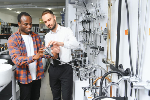 young african man choosing faucets standing with salesman near showcase plumbing shop 255667 84644.jpg