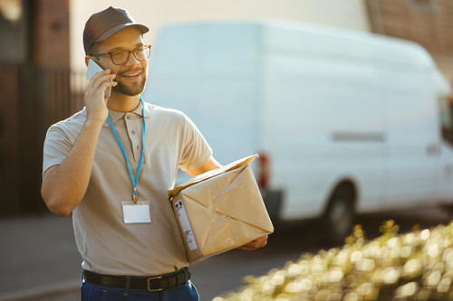 happy courier communicating cell phone while making delivery city 637285 2308.jpg