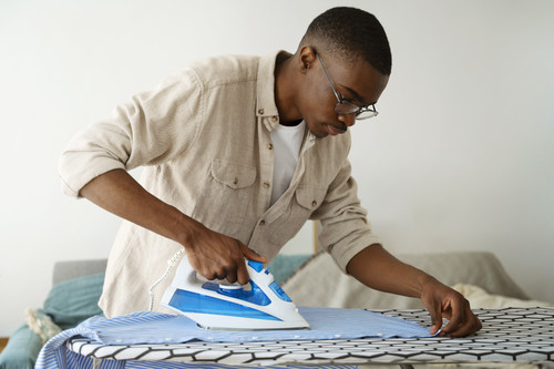 medium shot man servant ironing shirt.jpg