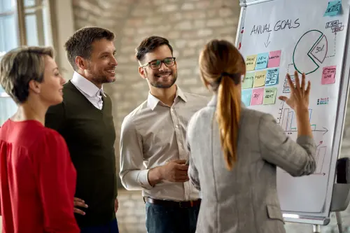 happy business team cooperating while analyzing their business progress whiteboard office.webp