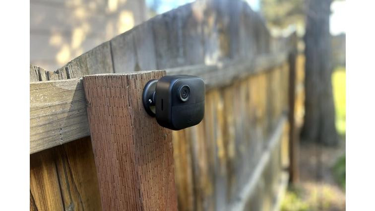 None The Blink Outdoor 4 camera connected to a wooden fence post.