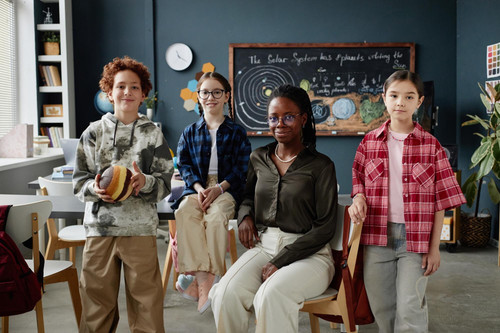 portrait young female teacher with diverse children posing classroom 236854 70395.jpg