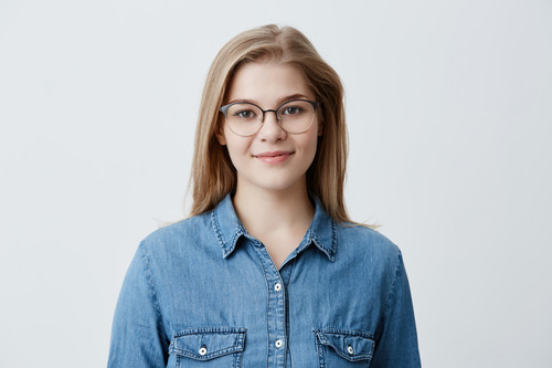 Horizontal portrait of smiling happy young pleasant looking female wears denim shirt and stylish gla.jpg