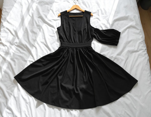 Firefly A realistic photo taken from above. A black deigner dress is neatly laid out on the b 967486.jpg