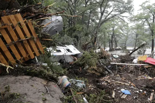 Damaged vehicles and debris are seen roped off near the banks of the Guadalupe River after flooding in Ingram, Texas, Friday, July 4, 2025.
