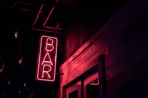 neon BAR sign lights up the doorway of a drinking establishment at night.jpg
