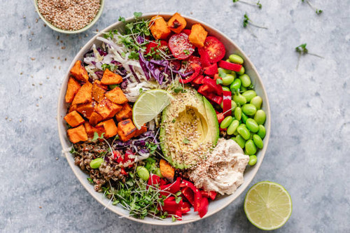 Overhead view of a colourful vegan bowl with quinoa, sweet potato, avocado, hummus and variety of ve.jpg