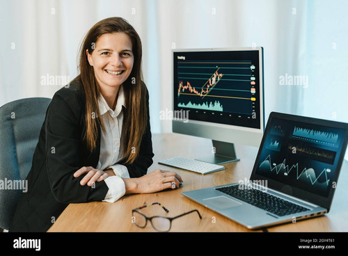 cheerful woman trading on binary option in office 2GY4T61.jpg