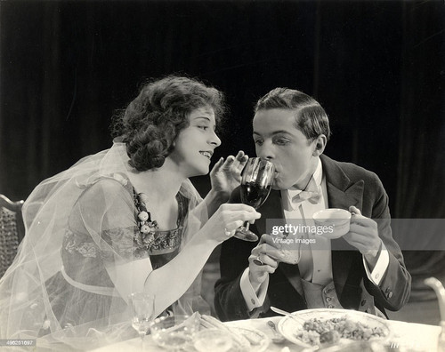 American actress Ethel Grandin (1894 - 1988) holds a wine glass for a man in a tuxedo in a still fro.jpg