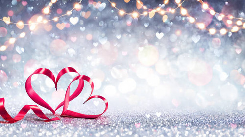 Red Ribbon Shaped Hearts On Silver Shiny Background With Lights.jpg