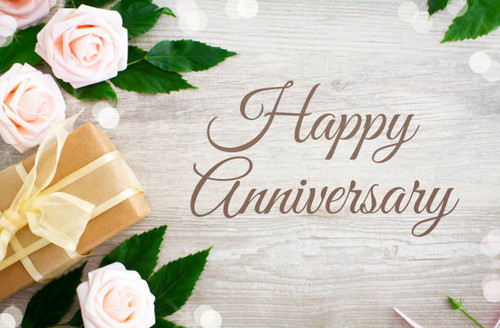 Happy Anniversary with pink roses and a gift with gold ribbon on a rustic wooden table.Shot from abo.jpg