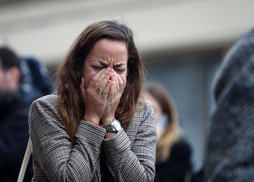 A women shows emotion outside Le Carillon bar.jpg