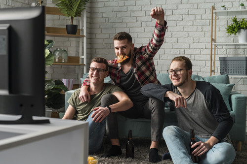front view of male friends having pizza and watching sports on tv.jpg