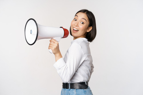 beautiful young asian woman talking megaphone screams speakerphone smiling making announcement shout.jpg