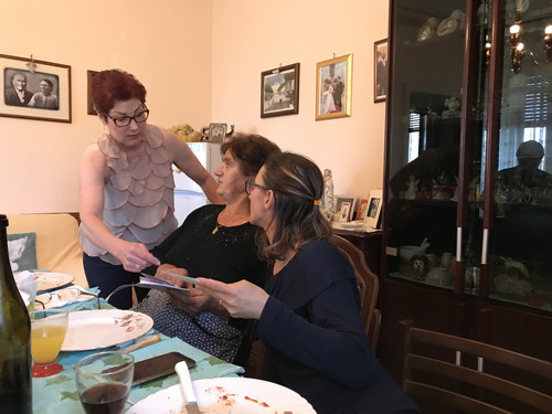 Showing Steve's, Jeff's, and Chris' family photos to Angelina and Filomena.jpg